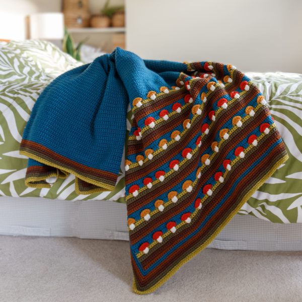 mid-century crochet throw in deep blue and browns featuring mustard and red mushrooms in rows midcentury mushrooms throw crochet pattern